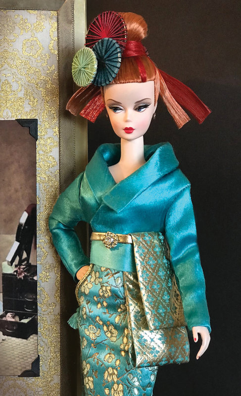 “Silkstone Mariko, a descendant of Japan’s highest courtesans from the Edo Period, borrows from the past but lives in the present, dressed in a modern silk and satin ‘kimono’ with unconventional pockets. Her custom two-tone hair is rerooted and styled by Seth Hanson. Mariko was made for the 2019 Grant-A-Wish, ‘Journey to Japan’ Doll Convention and is now in a private collection.”