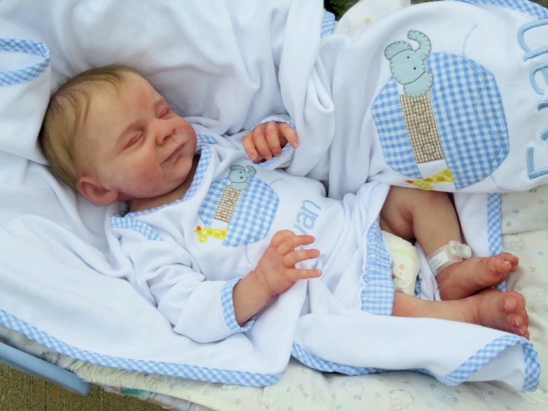 A lifelike baby doll sculpted as sleeping.