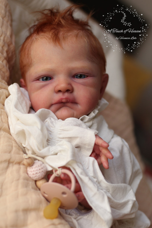 Realistic baby doll, looking at the camera.