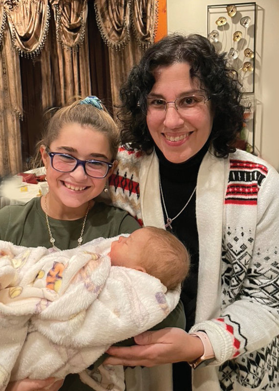 Laura Tuzio-Ross with her younger cousin and kindred spirit, Regan. Regan holds a baby doll.