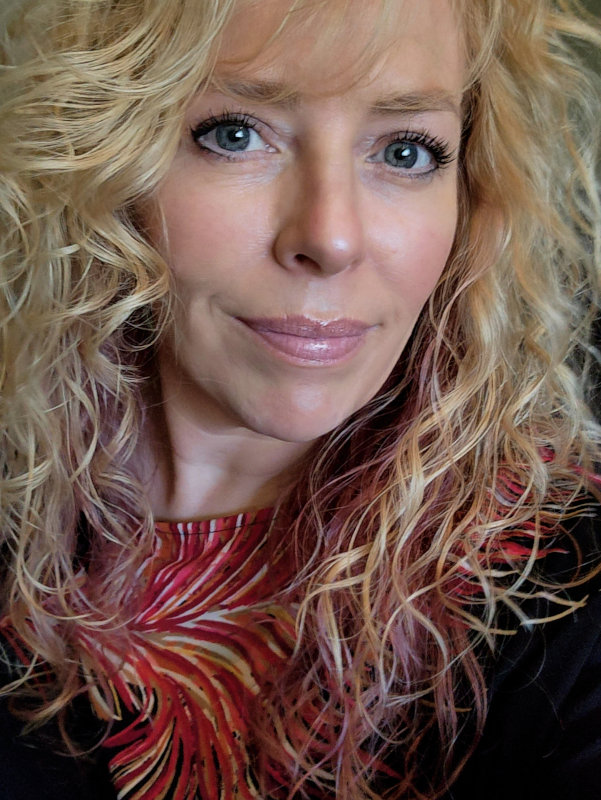 Closeup of a smiling blond woman with long hair.